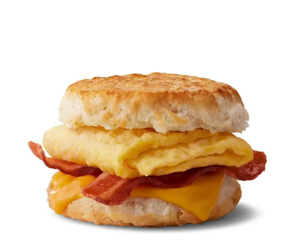 A warm biscuit sandwich filled with crispy bacon, a freshly cracked egg, and melted cheese.