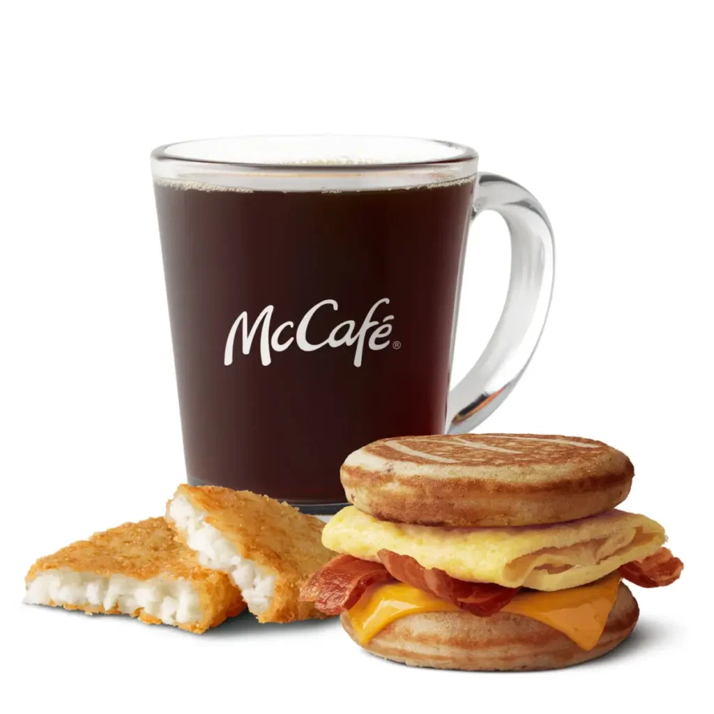 Sweet maple-flavored griddle cakes with bacon, egg, and cheese, served with hash browns and a drink.