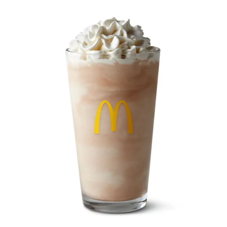 A McDonald's Chocolate Shake made with creamy soft-serve ice cream and rich chocolate syrup, topped with whipped cream.