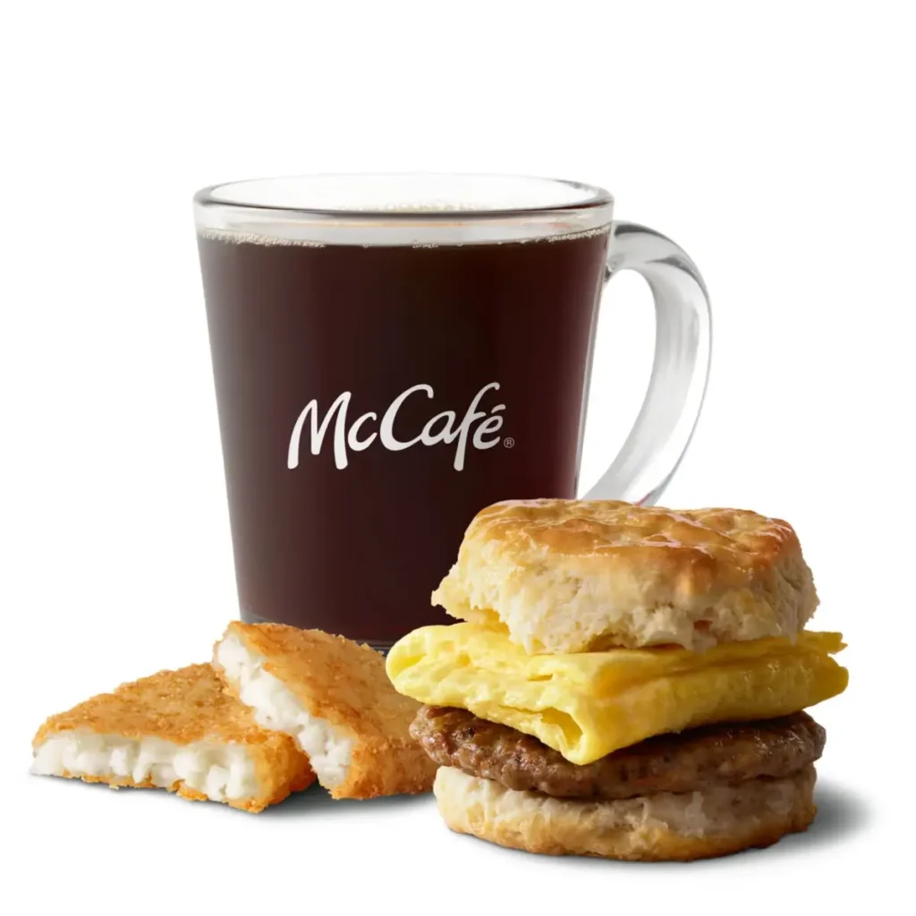 A Sausage Biscuit with Egg paired with hash browns and a drink for a complete breakfast.