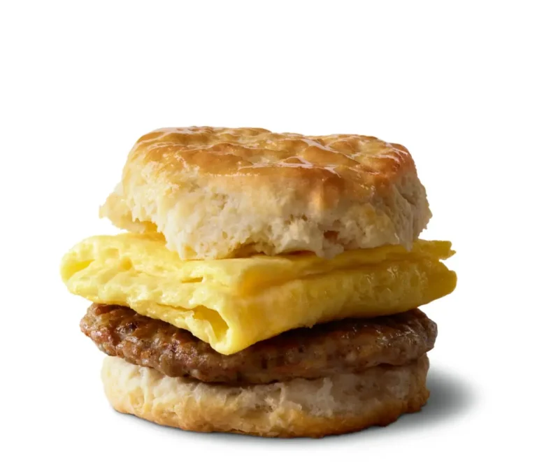 A flaky biscuit filled with a savory sausage patty and a freshly cracked egg for a hearty breakfast sandwich.