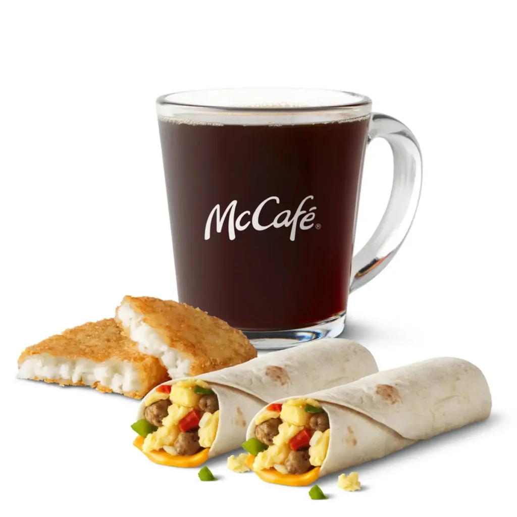 Two sausage burritos served with crispy hash browns and a drink for a convenient and filling breakfast.