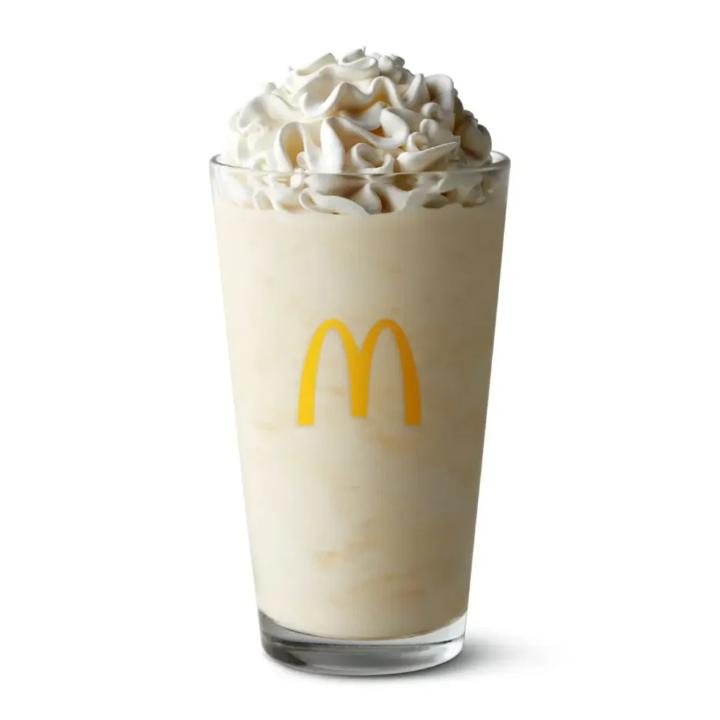 A McDonald's Vanilla Shake made with creamy soft-serve ice cream and topped with whipped cream.